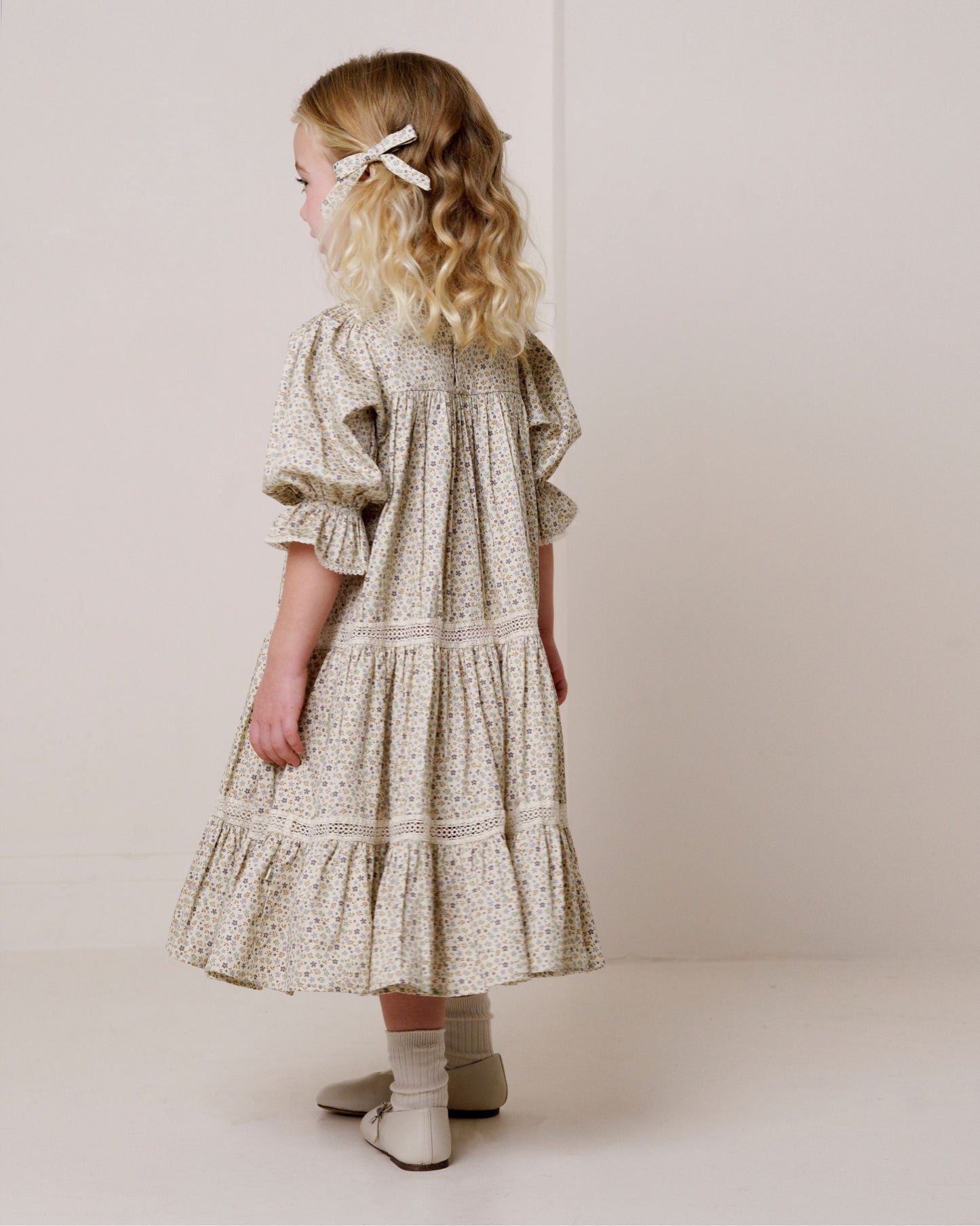 Early Sunday, Grace Clip in Mini Flowers print, made from Printed 60s Cotton Satin fabric, featuring a set of two bow clips with a secure fit, shown in a back view of model wearing it