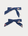 Early Sunday, Grace Clip in Ditsy Bouquet Navy Blue, made from Printed Cotton Satin fabric, featuring a set of two bow clips with a secure fit, shown in a front flat-lay view
