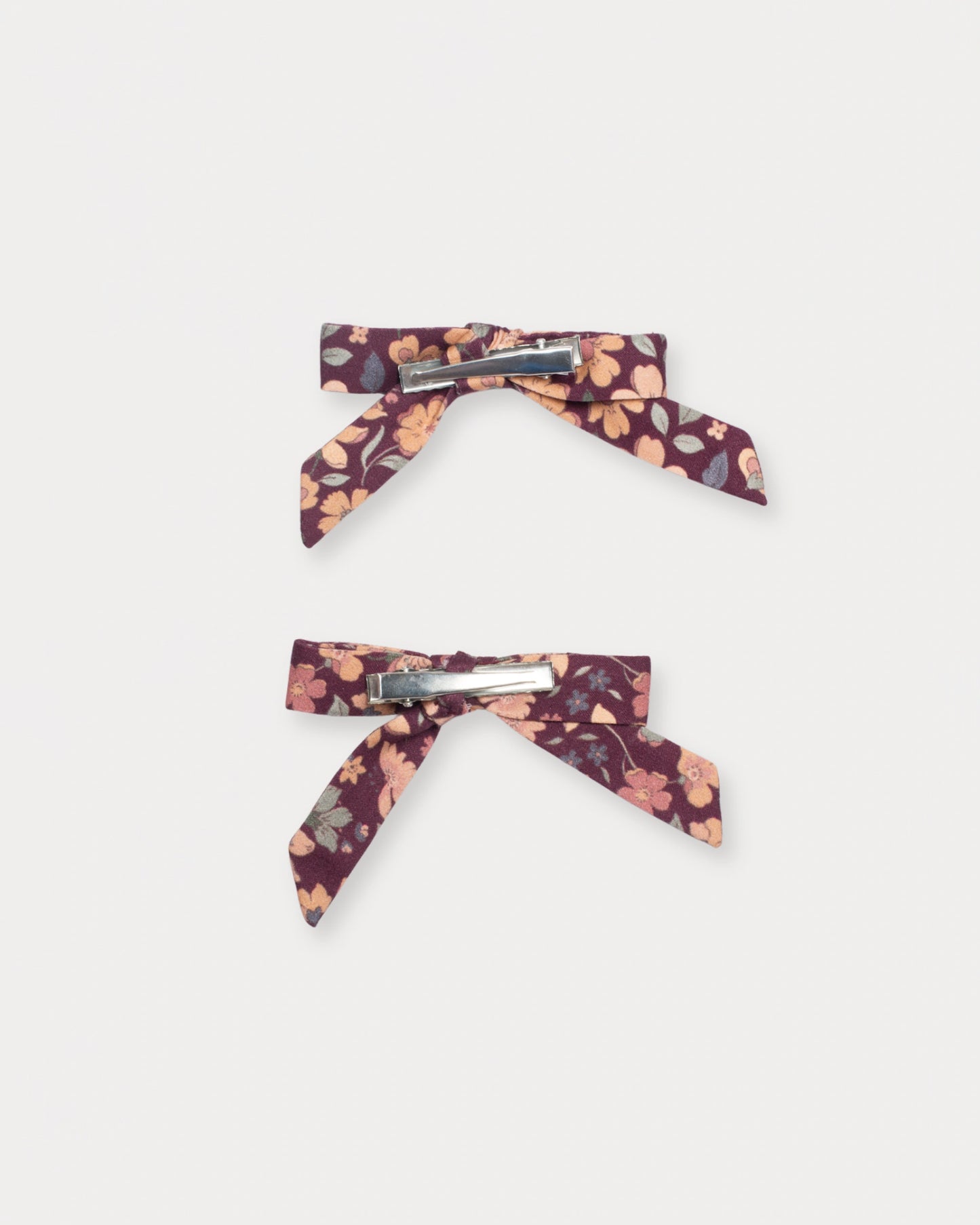 Early Sunday, Grace Clip in Garden Flowers Plum, made from Printed Cotton Satin fabric, featuring a set of two bow clips with a secure fit, shown in a back flat-lay view