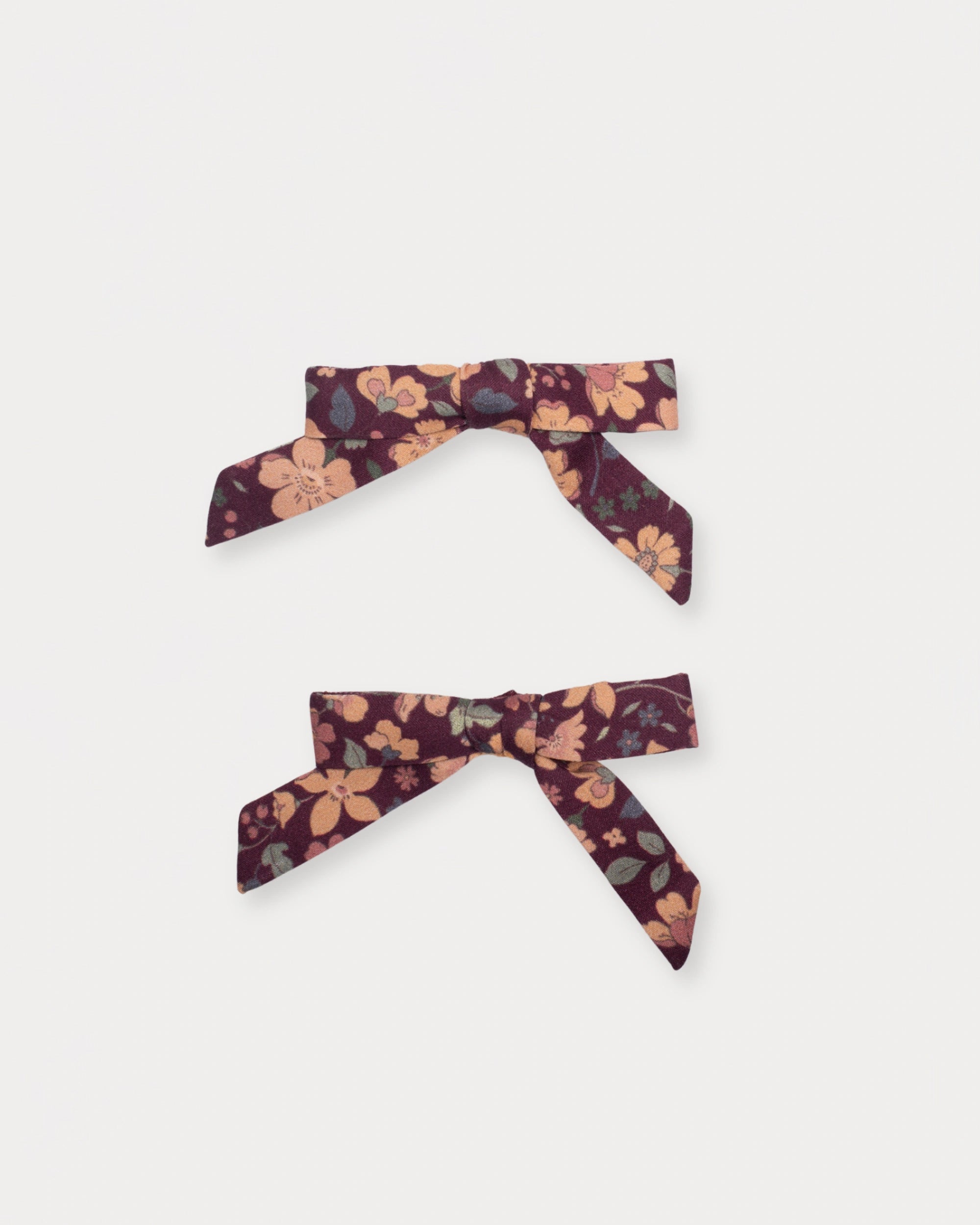 Early Sunday, Grace Clip in Garden Flowers Plum, made from Printed Cotton Satin fabric, featuring a set of two bow clips with a secure fit, shown in a front flat-lay view