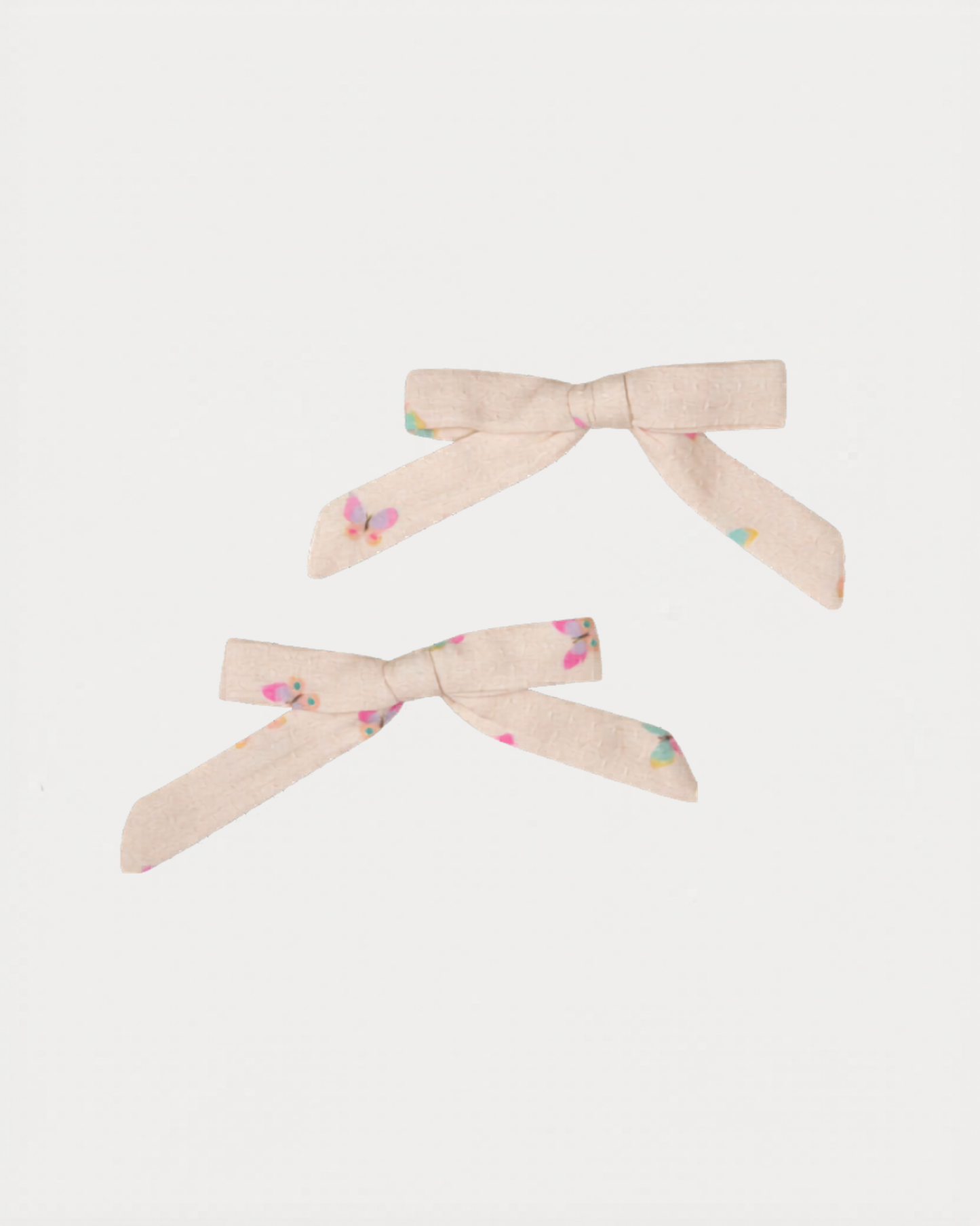 Early Sunday, Grace Clip in Butterflies print, made from Printed Cotton Tiny Swiss Dobby fabric, featuring a set of two bow clips with a secure fit, shown in a front flat-lay view