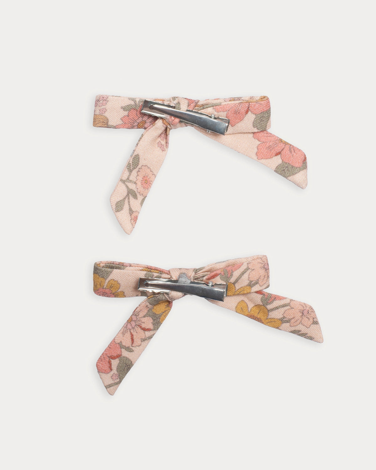 Early Sunday, Grace Clip in Bloom Blush, made from Printed Viscose Twill fabric, featuring a set of two bow clips with a secure fit, shown in a back flat-lay view