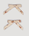 Early Sunday, Grace Clip in Ditsy Bouquet Cream print, made from Printed Viscose Twill fabric, featuring a set of two bow clips with a secure fit, shown in a front flat-lay view