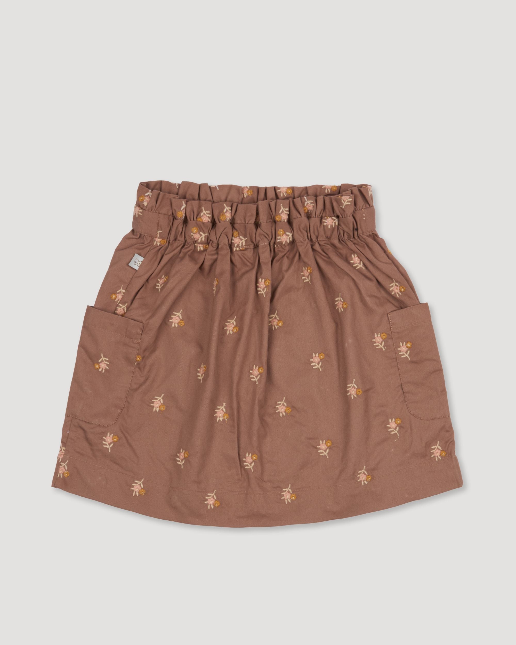 Early Sunday, Hilda Skirt in Bark, made from All-over embroidered 30s cotton brushed twill fabric, featuring A-line shape with a gathered elastic waistband for comfort, shown in a back flat-lay view