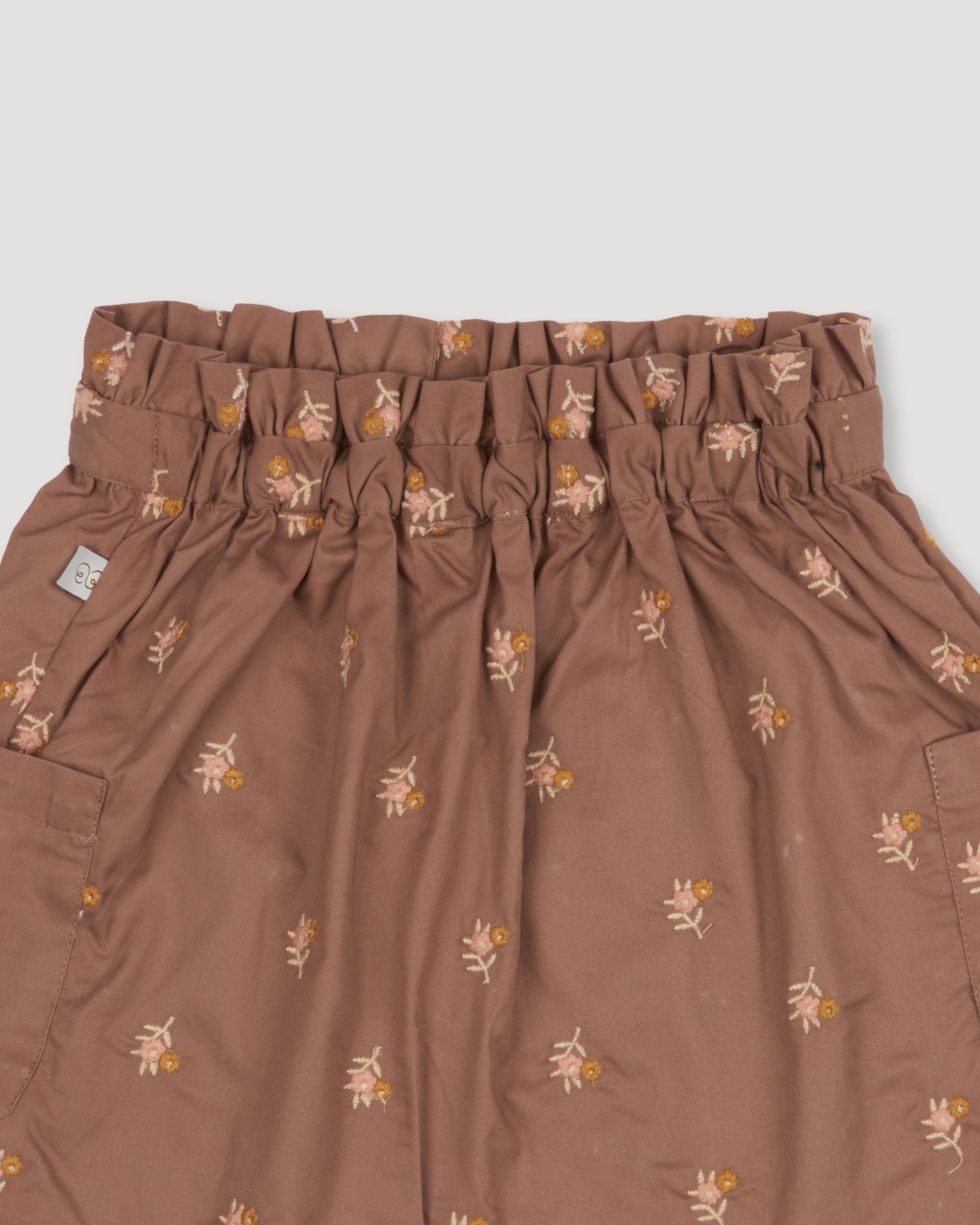 Early Sunday, Hilda Skirt in Bark, made from All-over embroidered 30s cotton brushed twill fabric, featuring A-line shape with a gathered elastic waistband for comfort, shown in a closeup flat-lay view