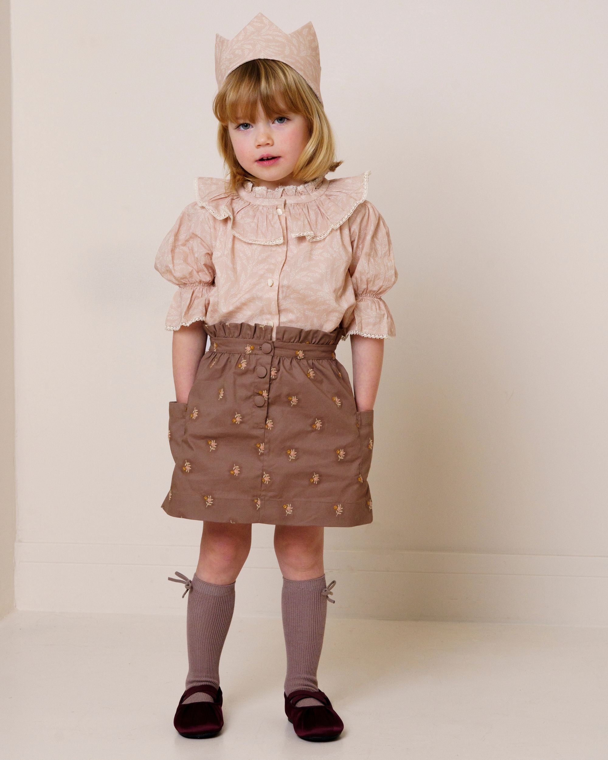 Early Sunday, Hilda Skirt in Bark, made from All-over embroidered 30s cotton brushed twill fabric, featuring A-line shape with a gathered elastic waistband for comfort, shown in a front view of model wearing it
