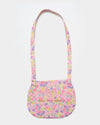 Early Sunday, Hudson Purse in Emma Floral Purple color, made from Organic Printed Cotton Cambric fabric, featuring a gathered sling purse design with a flap closure, shown in back flat-lay view