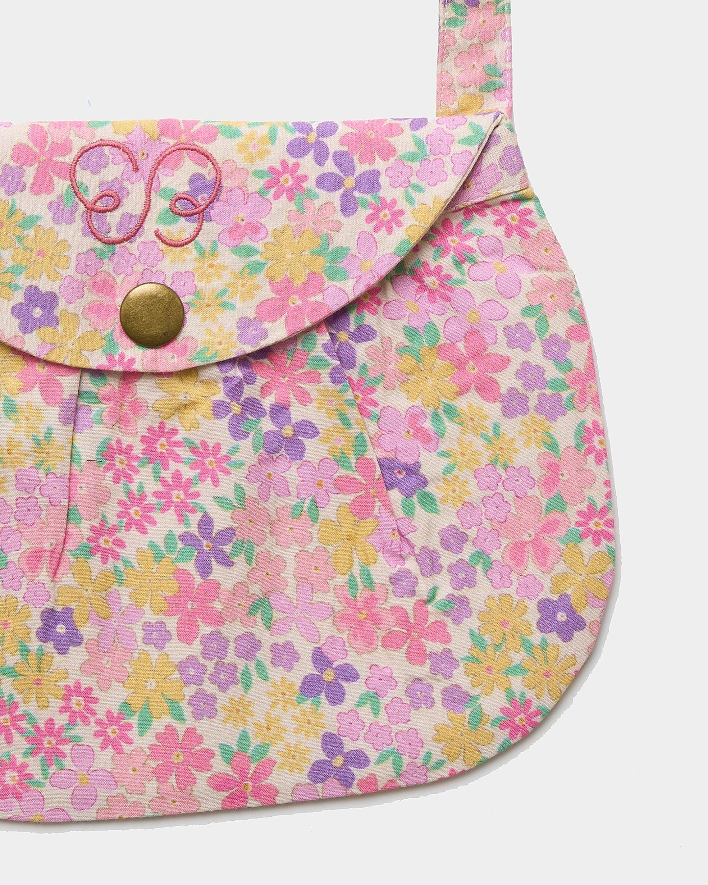 Early Sunday, Hudson Purse in Emma Floral Purple color, made from Organic Printed Cotton Cambric fabric, featuring a gathered sling purse design with a flap closure, shown in closeup flat-lay view