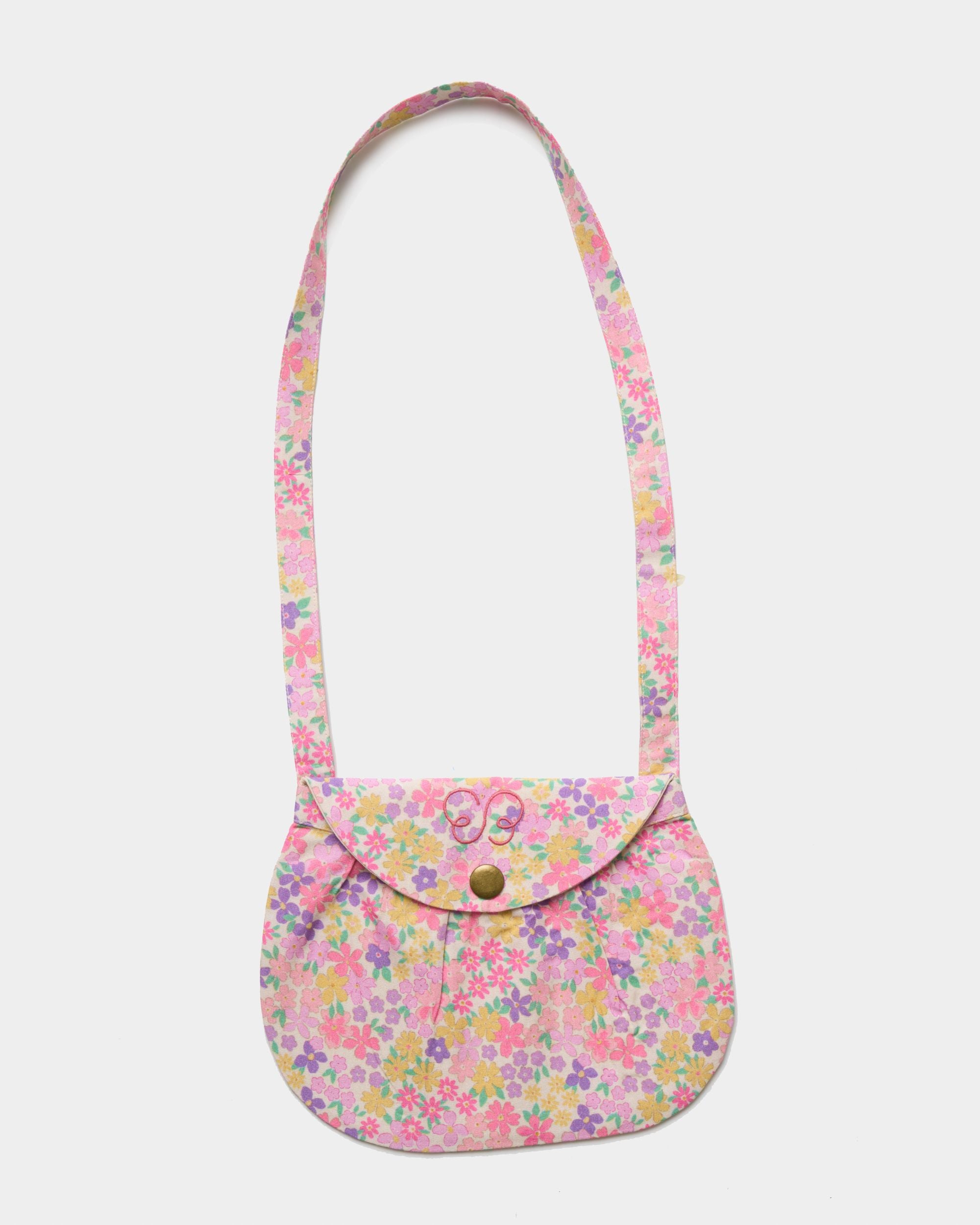 Early Sunday, Hudson Purse in Emma Floral Purple color, made from Organic Printed Cotton Cambric fabric, featuring a gathered sling purse design with a flap closure, shown in front flat-lay view