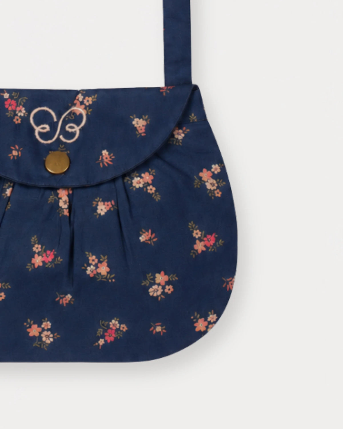 Early Sunday, Hudson Purse in Ditsy Bouquet Navy Blue, made from Printed Cotton Satin fabric, featuring a gathered sling purse design with a flap closure, shown in a closeup flat-lay view