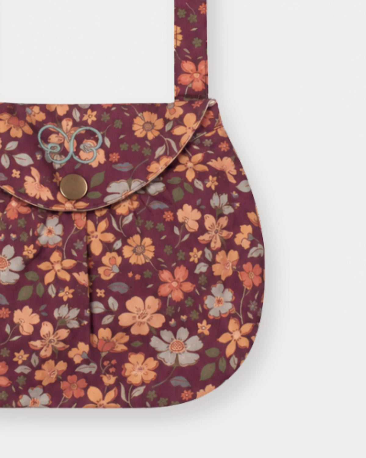 Early Sunday, Hudson Purse in Garden Flowers Plum, made from Printed Cotton Satin fabric, featuring a gathered sling purse design with a flap closure, shown in a closeup flat-lay view