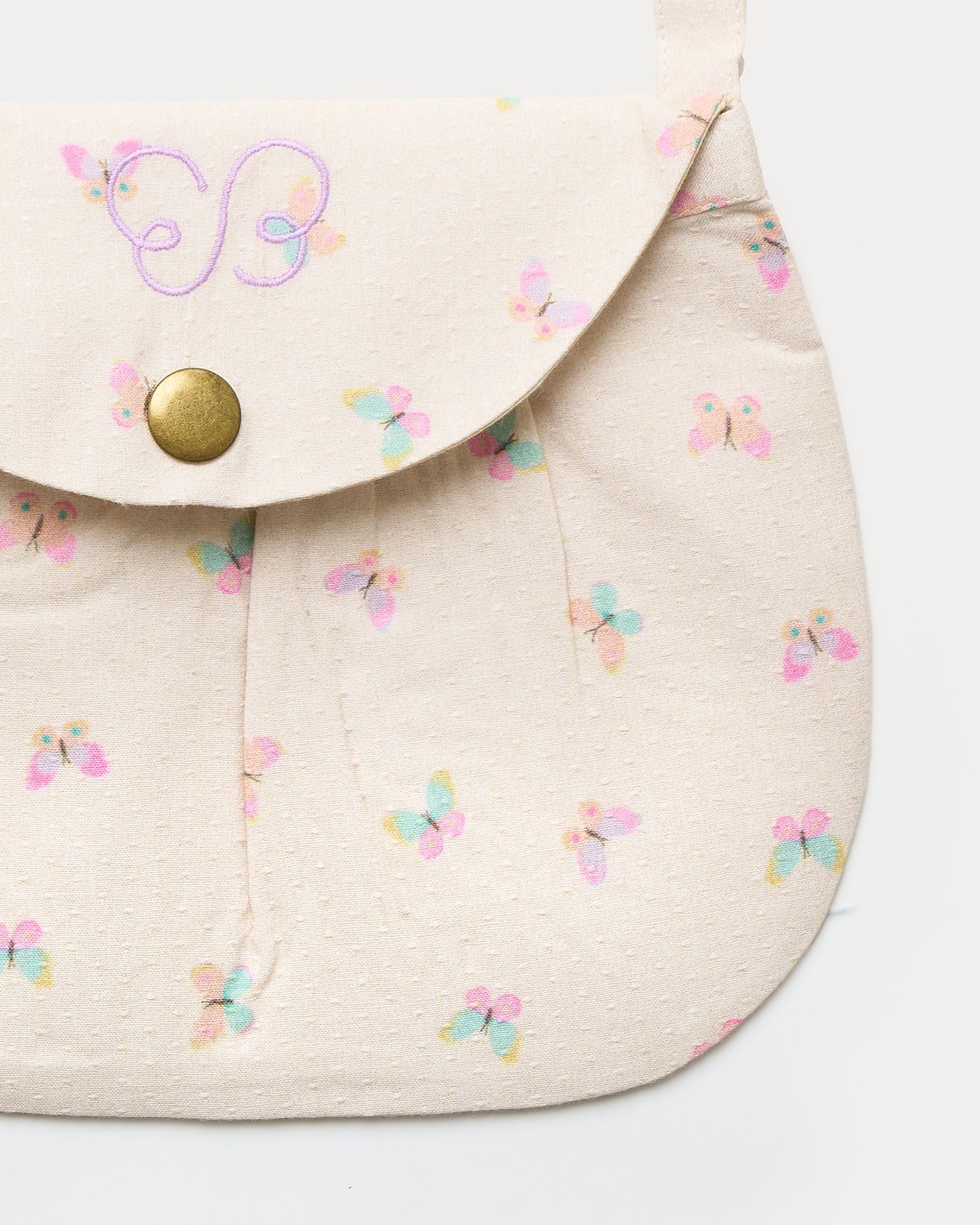 Early Sunday, Hudson Purse in Butterflies print, made from Printed Cotton Tiny Swiss Dobby fabric, featuring a gathered sling purse design with a flap closure, shown in a closeup flat-lay view