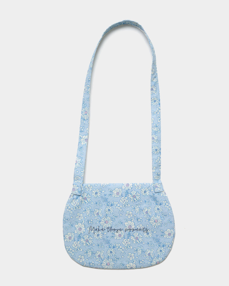 Early Sunday, Hudson Purse in Tonal Floral Blue color, made from Printed Cotton Tiny Swiss Dobby fabric, featuring a gathered sling purse design with a flap closure, shown in back flat-lay view