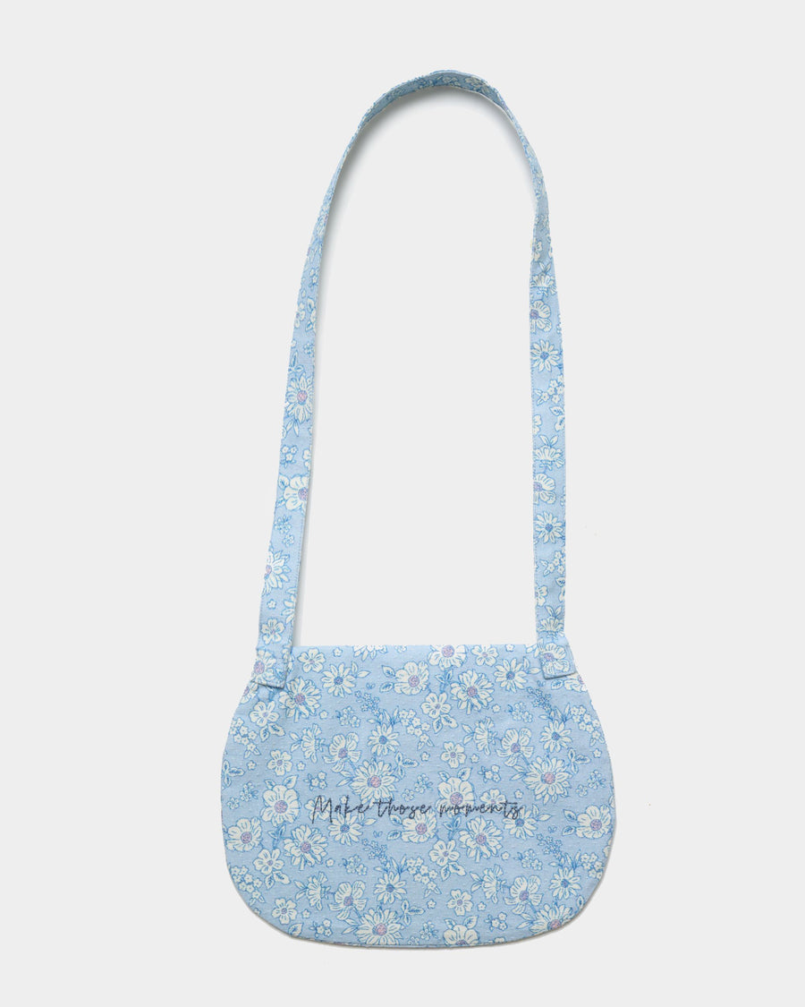 Early Sunday, Hudson Purse in Tonal Floral Blue color, made from Printed Cotton Tiny Swiss Dobby fabric, featuring a gathered sling purse design with a flap closure, shown in back flat-lay view