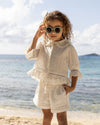 Early Sunday, Iris Blouse in Ivory color, made from All-Over Eyelet Embroidered Cotton Schifflie fabric, featuring relaxed fit with delicate detailing for a timeless and feminine look, shown in a front view of model wearing it