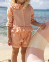 Early Sunday, Iris Blouse & Roman Shorts in Strawberry color, made from All-Over Eyelet Embroidered Cotton Schifflie fabric, featuring relaxed fit with delicate detailing for a timeless and feminine look, shown in a close up shot of model wearing it