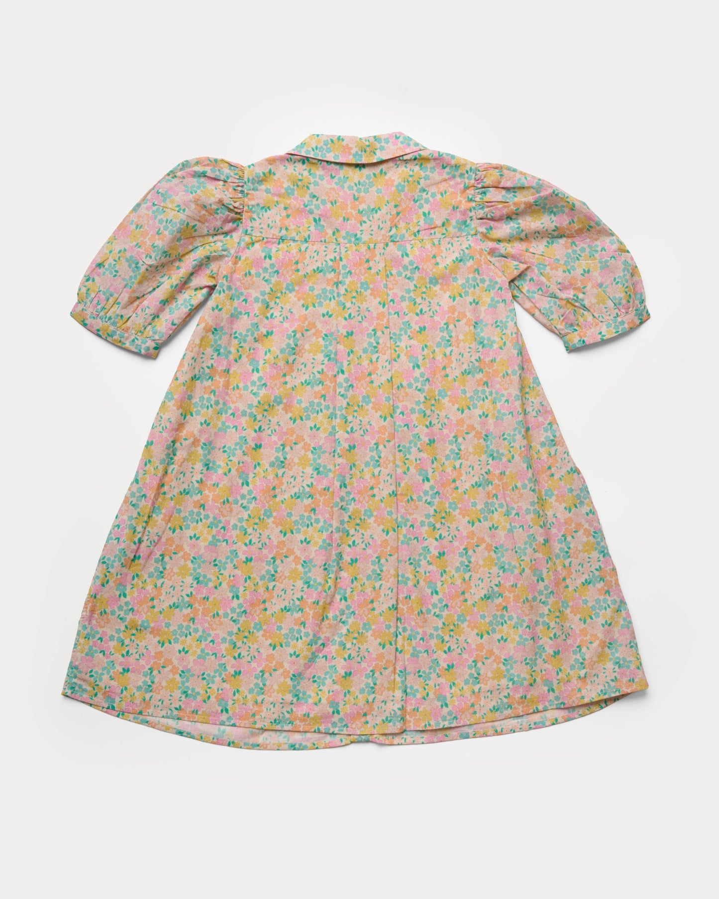 Early Sunday, Jane Dress in Emma Floral Mint color, made from printed 60s cotton cambric fabric, featuring Smocked / embroidered yoke, peter pan collar and puffed short sleeves, shown in a back flat-lay view