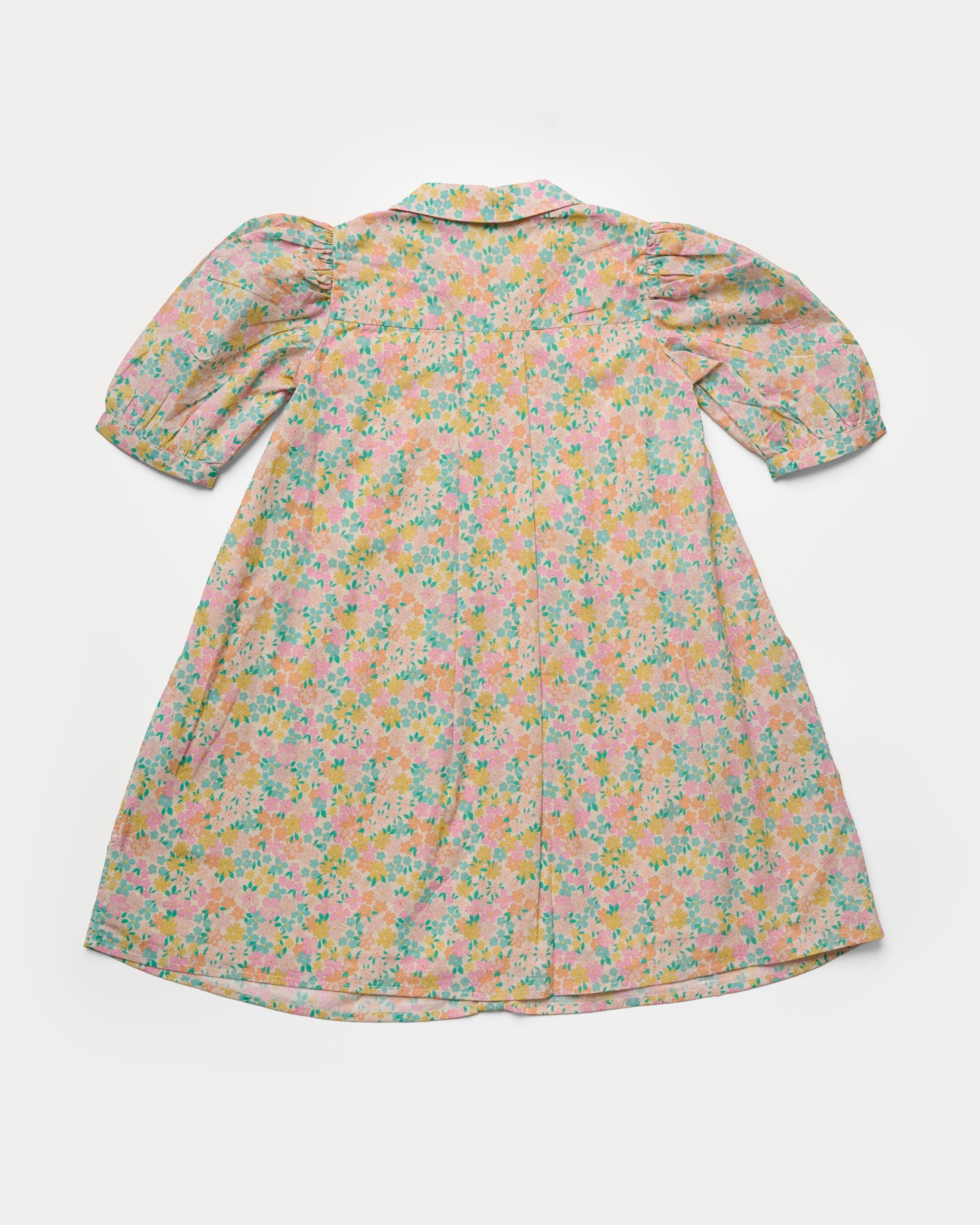 Early Sunday, Jane Dress in Emma Floral Mint color, made from printed 60s cotton cambric fabric, featuring Smocked / embroidered yoke, peter pan collar and puffed short sleeves, shown in a back flat-lay view