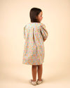 Early Sunday, Jane Dress in Emma Floral Mint color, made from printed 60s cotton cambric fabric, featuring Smocked / embroidered yoke, peter pan collar and puffed short sleeves, shown in a back view of model wearing
