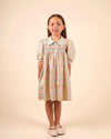 Early Sunday, Jane Dress in Emma Floral Mint color, made from printed 60s cotton cambric fabric, featuring Smocked / embroidered yoke, peter pan collar and puffed short sleeves, shown in a front view of model wearing