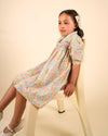 Early Sunday, Jane Dress in Emma Floral Mint color, made from printed 60s cotton cambric fabric, featuring Smocked / embroidered yoke, peter pan collar and puffed short sleeves, shown in a close up shot of model wearing it