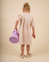 Early Sunday, Jane Dress in Butterfly Print color, made from printed cotton tiny swiss dobby fabric, featuring Smocked / embroidered yoke, peter pan collar and puffed short sleeves, shown in a back view of model wearing
