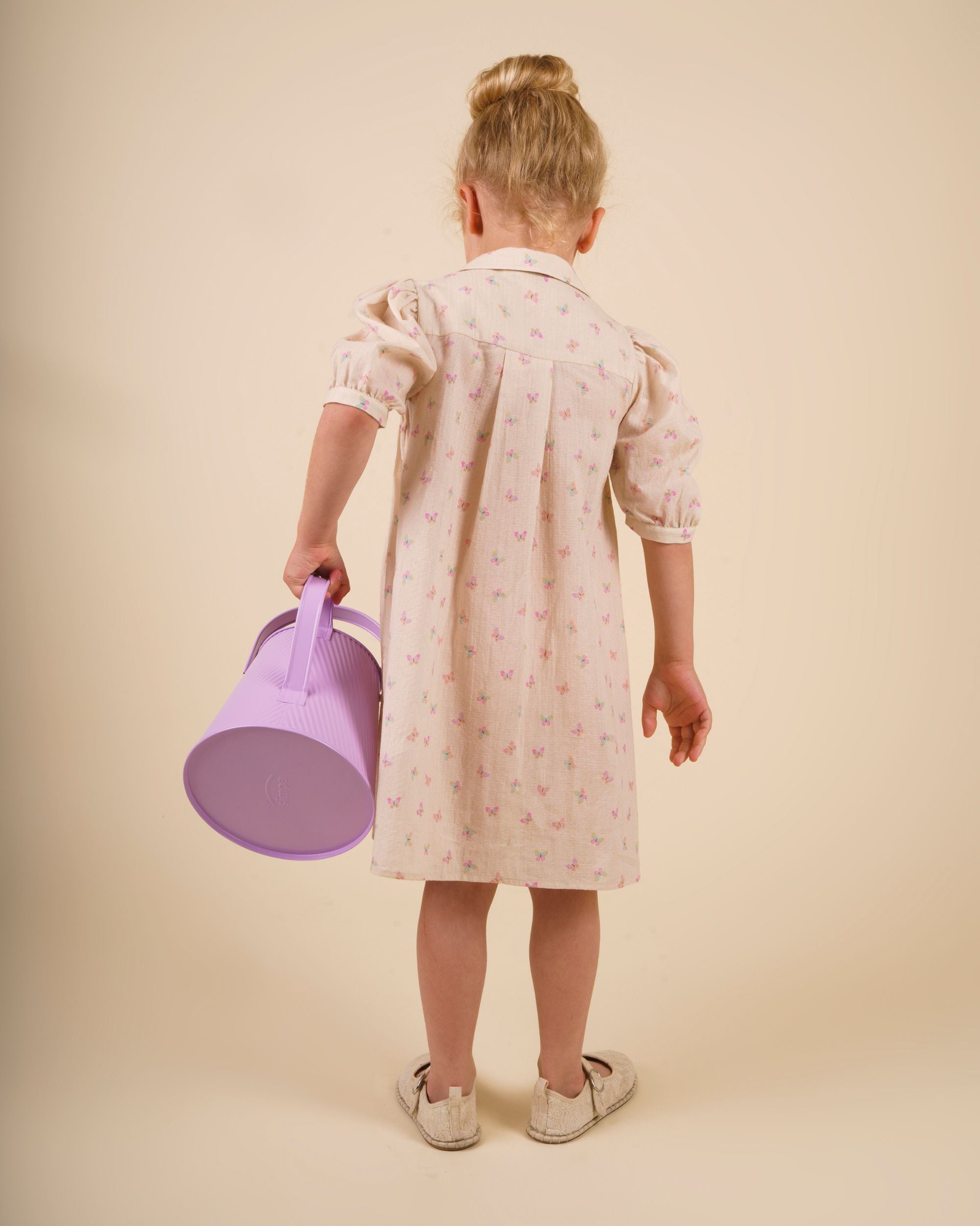 Early Sunday, Jane Dress in Butterfly Print color, made from printed cotton tiny swiss dobby fabric, featuring Smocked / embroidered yoke, peter pan collar and puffed short sleeves, shown in a back view of model wearing