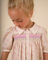 Early Sunday, Jane Dress in Butterfly Print color, made from printed cotton tiny swiss dobby fabric, featuring Smocked / embroidered yoke, peter pan collar and puffed short sleeves, shown in a close up shot of model wearing it