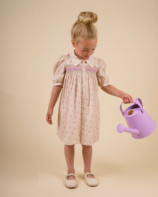 Early Sunday, Jane Dress in Butterfly Print color, made from printed cotton tiny swiss dobby fabric, featuring Smocked / embroidered yoke, peter pan collar and puffed short sleeves, shown in a front view of model wearing