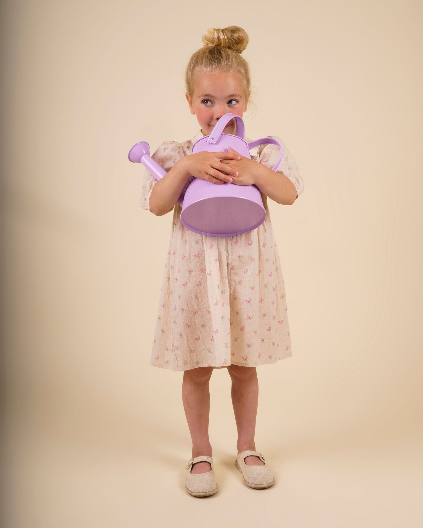 Early Sunday, Jane Dress in Butterfly Print color, made from printed cotton tiny swiss dobby fabric, featuring Smocked / embroidered yoke, peter pan collar and puffed short sleeves, shown in a model standing facing front wearing