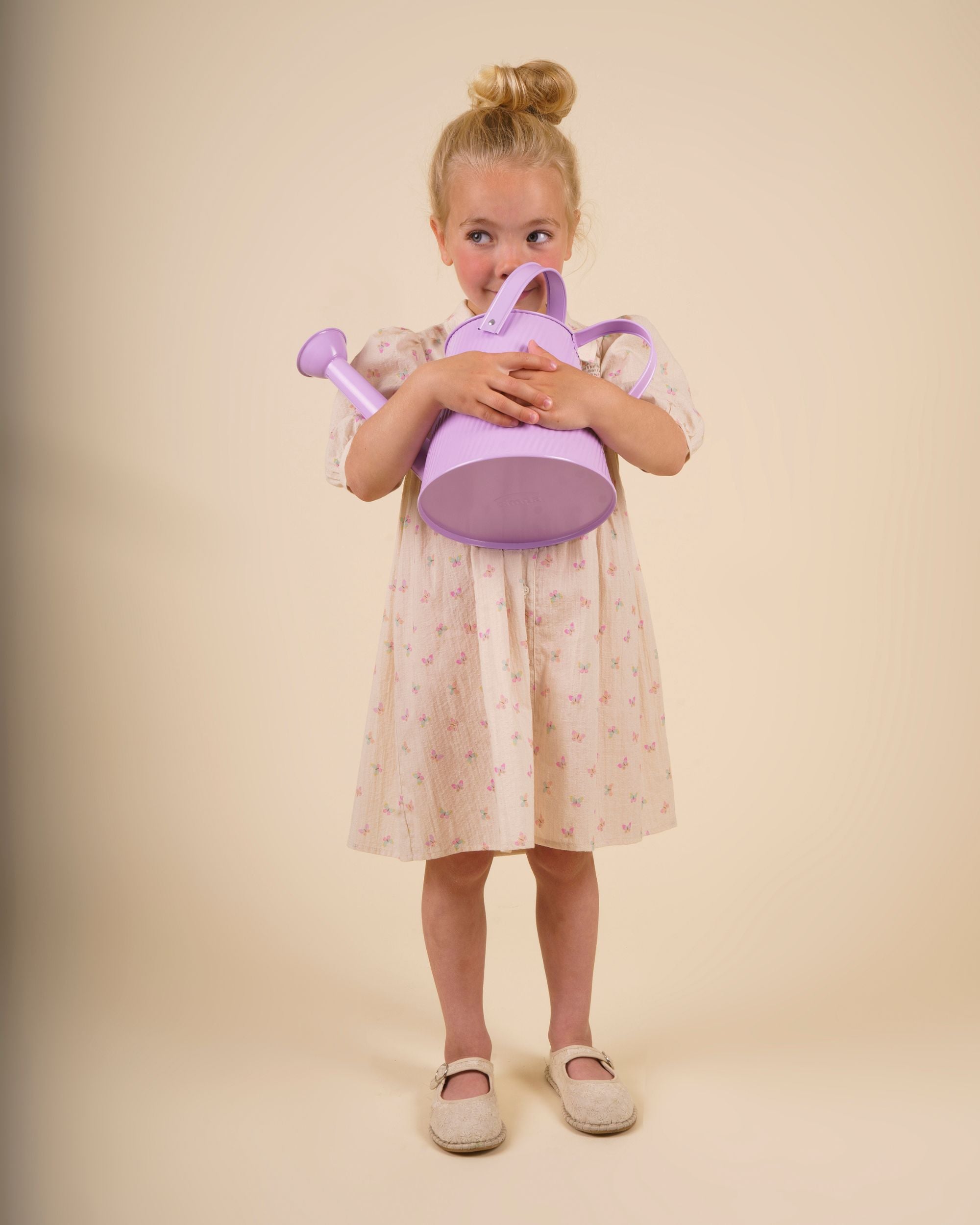 Early Sunday, Jane Dress in Butterfly Print color, made from printed cotton tiny swiss dobby fabric, featuring Smocked / embroidered yoke, peter pan collar and puffed short sleeves, shown in a model standing facing front wearing