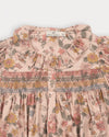 Early Sunday, Jeanette Dress in Bloom, made from Printed Viscose Twill fabric, featuring smocked chest with frilled neckline and soft gathered puff sleeves, shown in a closeup flat-lay view