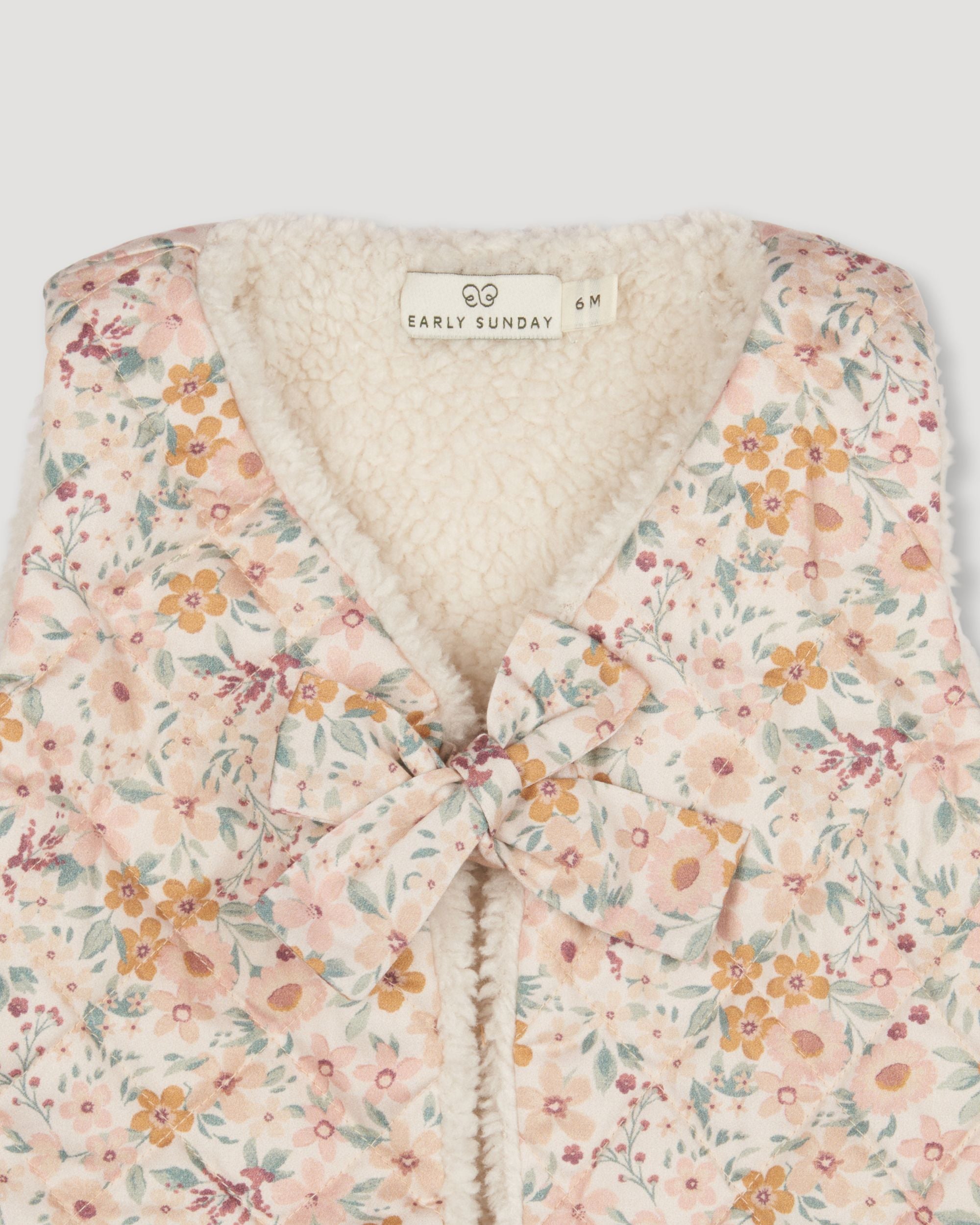 Early Sunday, Jilly Gilet in Floral print, made from Printed 60s Cotton Satin fabric, featuring a sleeveless gilet design with soft padding, shown in a closeup flat-lay view