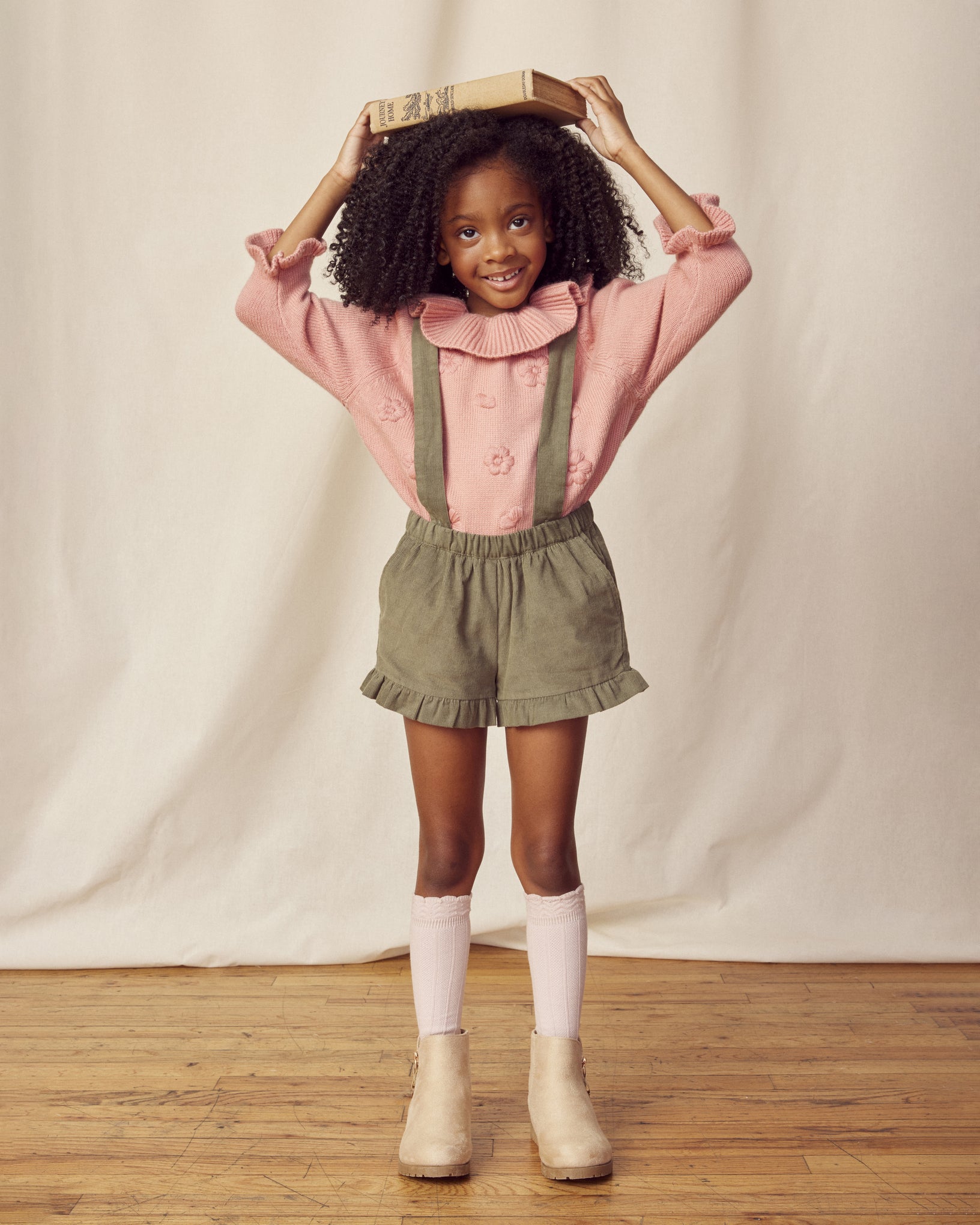 Early Sunday, Joseph Short Dungaree in Moss, made from Cotton Corduroy fabric, featuring short dungaree with adjustable straps, shown in a front view of model wearing it