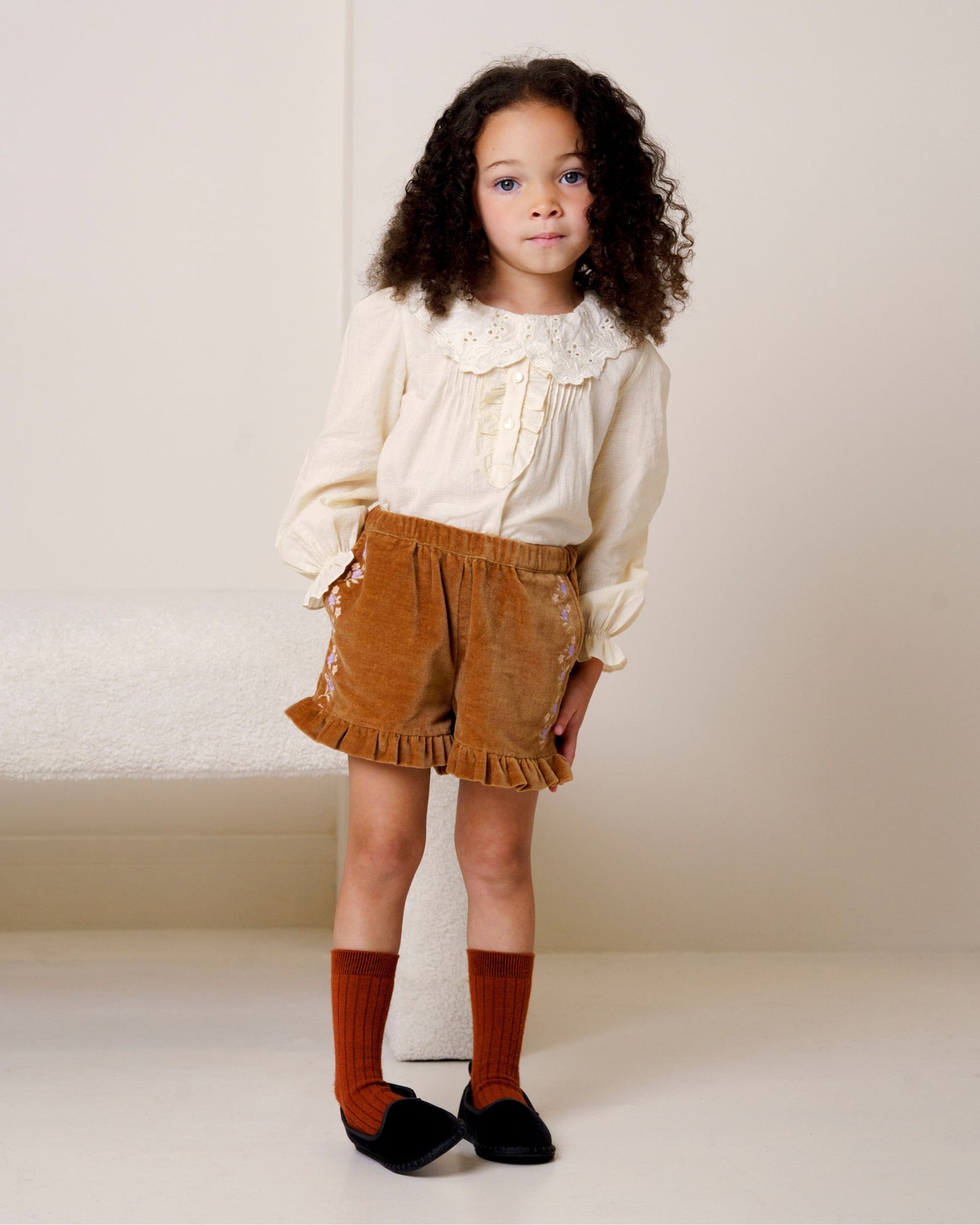 Early Sunday, Joseph Short Dungaree in Almond, made from Dyed Cotton Velvet fabric, featuring Softly structured short dungaree with classic detailing for a vintage-inspired look, shown in a front view of model wearing it
