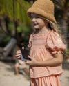 Early Sunday, Judith Blouse in Strawberry color, made from Cotton Dobby Swiss Dots fabric, featuring relaxed fit with delicate finishes, combining style and functionality, shown in a side view of model wearing it