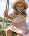 Early Sunday, Judith Blouse in Warm Sand color, made from Cotton Seersucker fabric, featuring relaxed fit with delicate finishes, combining style and functionality, shown in a close up shot of model playing outdoors