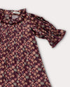 Early Sunday, Julie Dress in Plum, made from Printed Cotton Satin fabric, featuring detailed lace gathered sleeves with frilled neckline & floral detailing, shown in a closeup flat-lay view