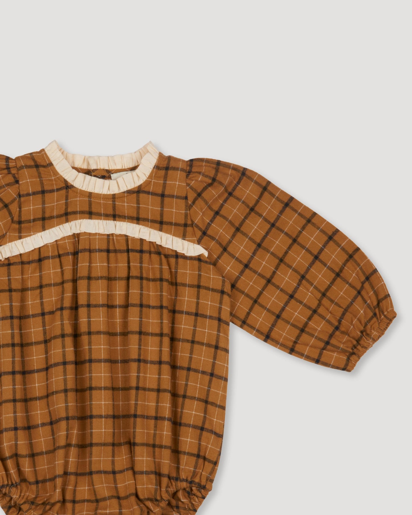 Early Sunday, Kayla Baby Romper in Almond Checks print, made from Cotton Yarn Dyed Brushed Checks fabric, featuring long gathered sleeves & frilled neckline, shown in a closeup flat-lay view