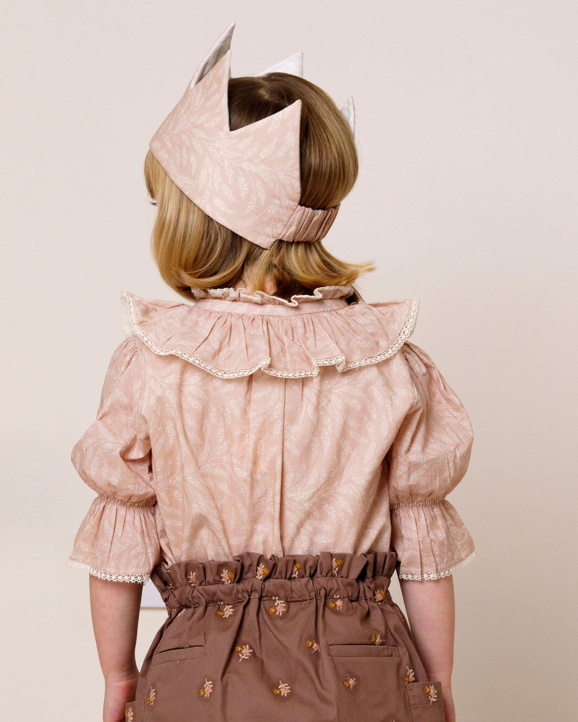 Early Sunday, Kids Crown in Feather print, made from Printed 60s Cotton Cambric fabric, featuring a design with pointed tips & an elasticated band, shown in a back view of model wearing it