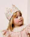 Early Sunday, Kids Crown in Floral print, made from Printed 60s Cotton Satin fabric, featuring a design with pointed tips & an elasticated band, shown in a close up shot of model wearing it