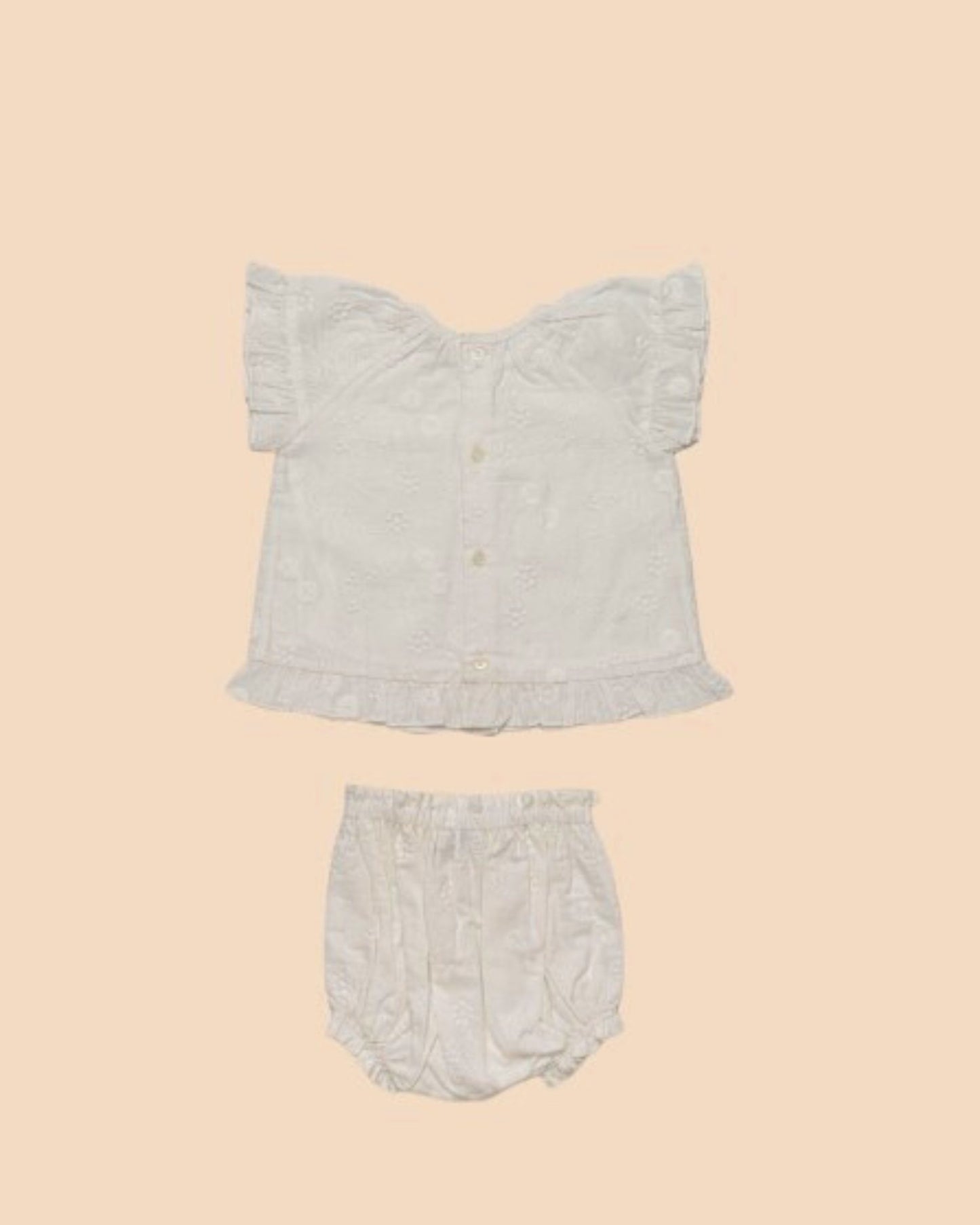 Early Sunday, Kitty Baby Blouse & Bloomer Set in Ivory color, made from 100% Cotton All Over Embroidery fabric, featuring a sleeveless flared sleeves with floral embroidery, shown in a back flat-lay view