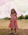 Early Sunday, Laura Dress in Candy Floss color, made from 100% cotton double gauze solid fabric, featuring Crisscross ruffle straps with delicate trim accents and a softly gathered tiered skirt, shown in a front view of model wearing