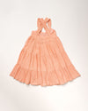 Early Sunday, Laura Dress in Candy Floss color, made from 100% cotton double gauze solid fabric, featuring Crisscross ruffle straps with delicate trim accents and a softly gathered tiered skirt, shown in a back flat-lay view
