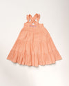 Early Sunday, Laura Dress in Candy Floss color, made from 100% cotton double gauze solid fabric, featuring Crisscross ruffle straps with delicate trim accents and a softly gathered tiered skirt, shown in a front flat-lay view