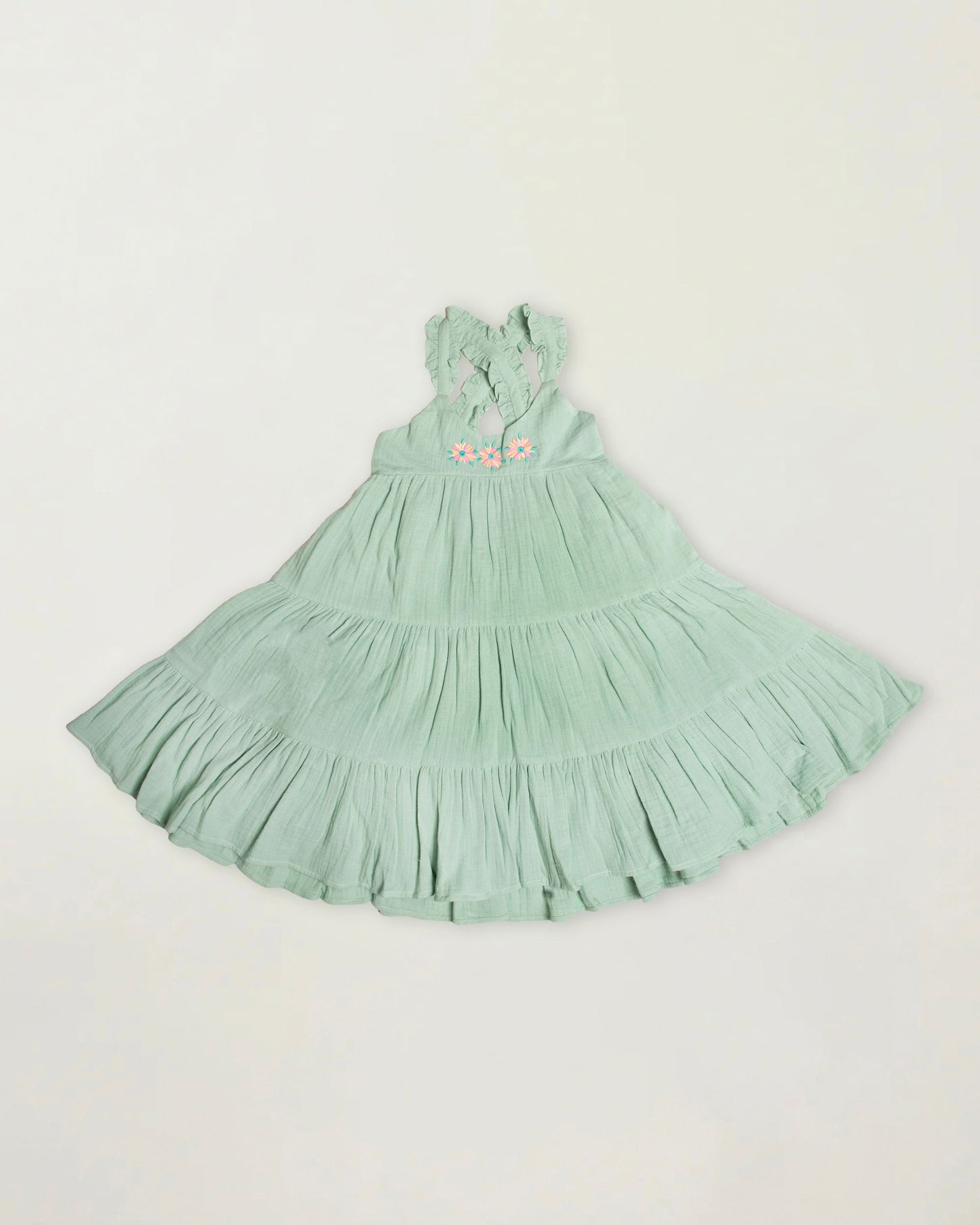 Early Sunday, Laura Dress in Mint color, made from 100% cotton double gauze solid fabric, featuring Crisscross ruffle straps with delicate trim accents and a softly gathered tiered skirt, shown in a front flat-lay view