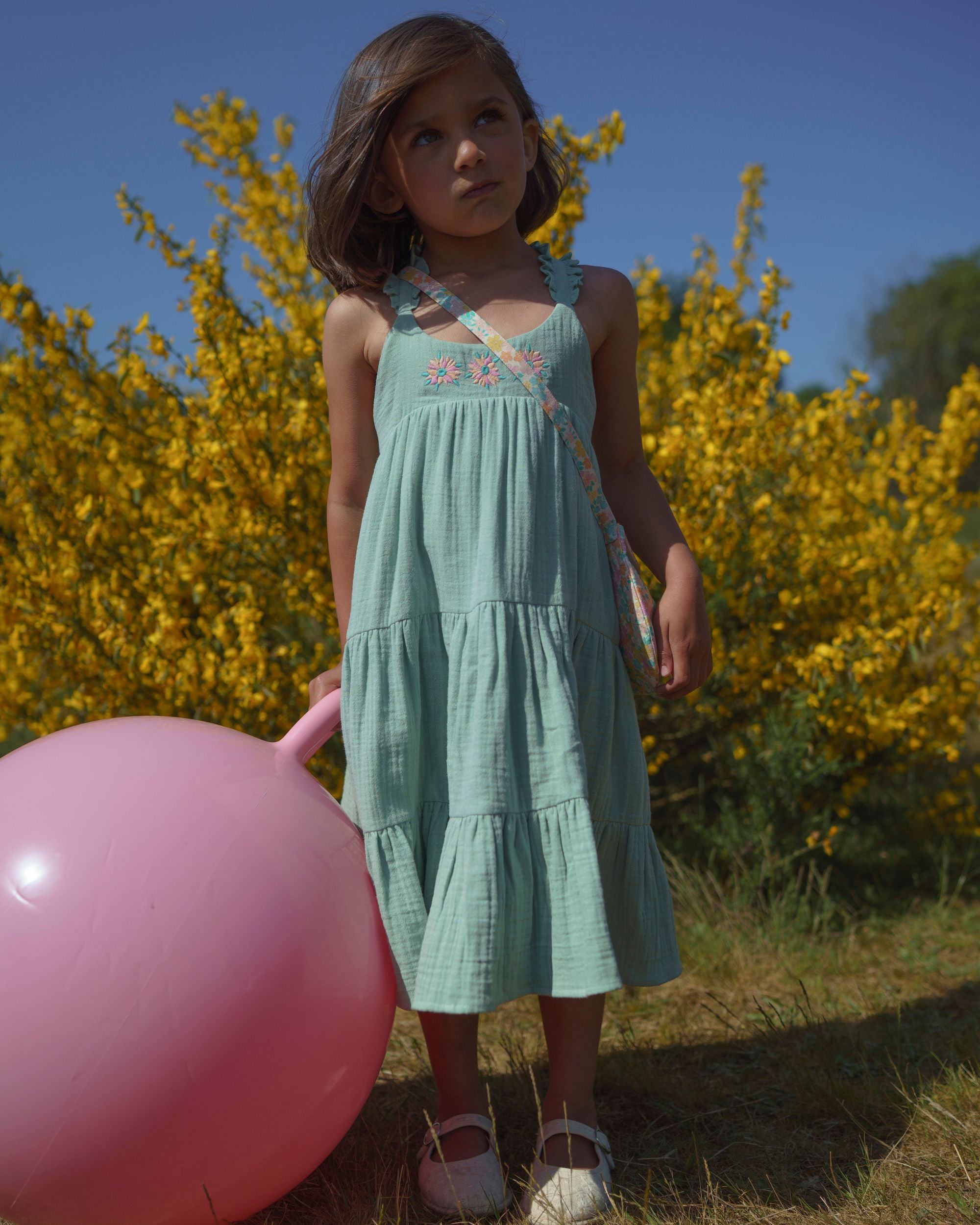 Early Sunday, Laura Dress in Mint color, made from 100% cotton double gauze solid fabric, featuring Crisscross ruffle straps with delicate trim accents and a softly gathered tiered skirt, shown in a front view of model wearing