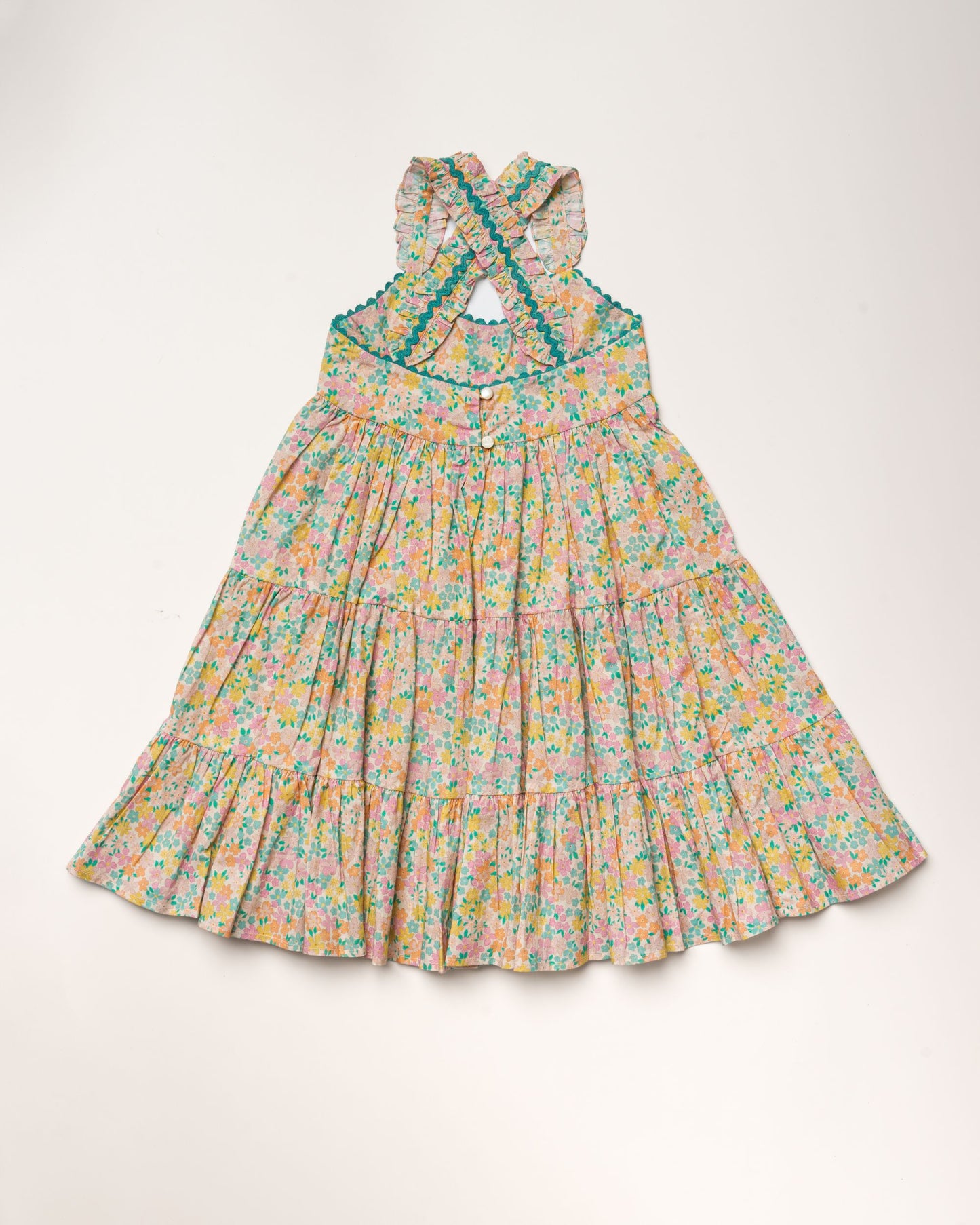 Early Sunday, Laura Dress in Emma Floral Mint color, made from printed 60s cotton cambric fabric, featuring Crisscross ruffle straps with delicate trim accents and a softly gathered tiered skirt, shown in a back flat-lay view