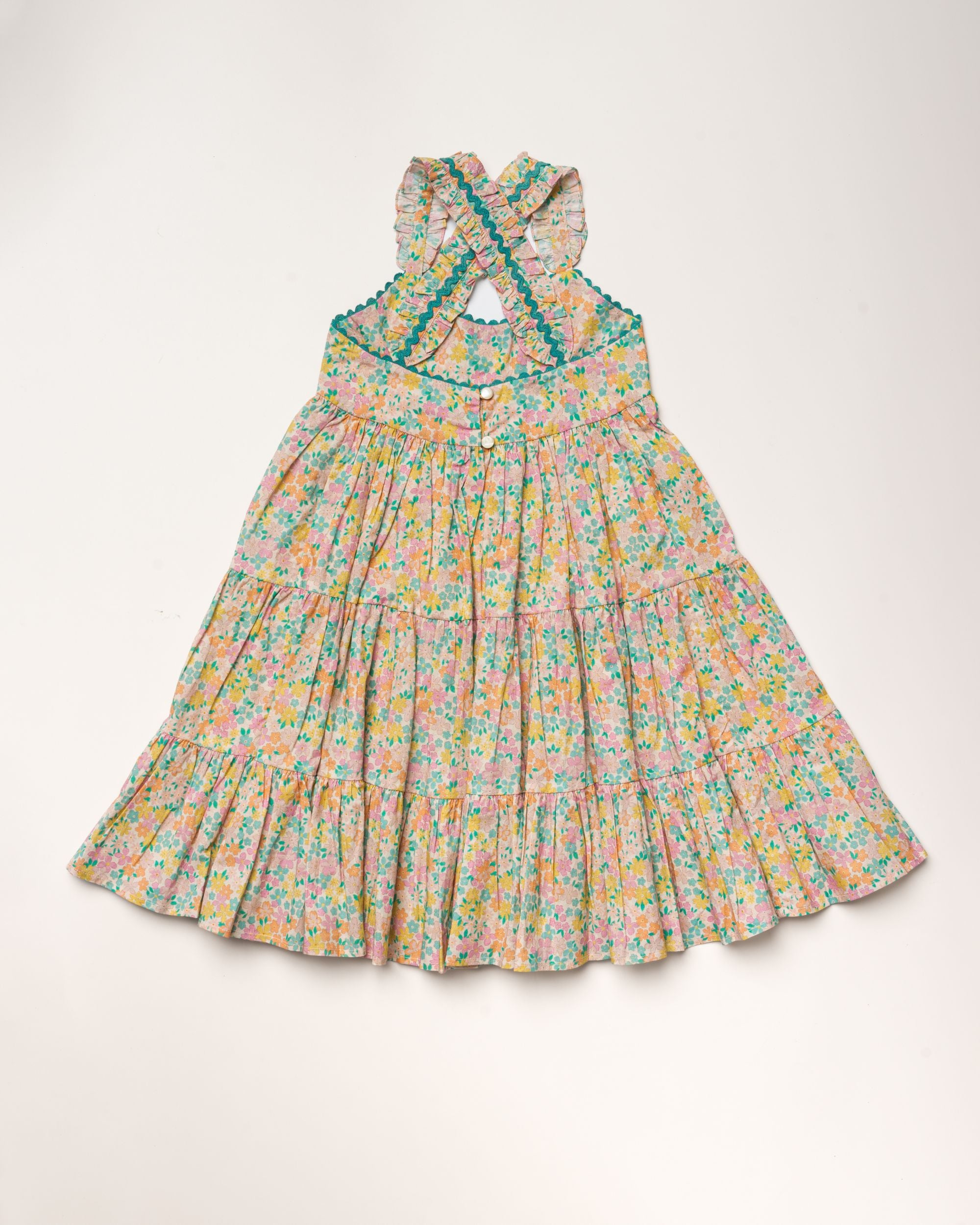 Early Sunday, Laura Dress in Emma Floral Mint color, made from printed 60s cotton cambric fabric, featuring Crisscross ruffle straps with delicate trim accents and a softly gathered tiered skirt, shown in a back flat-lay view