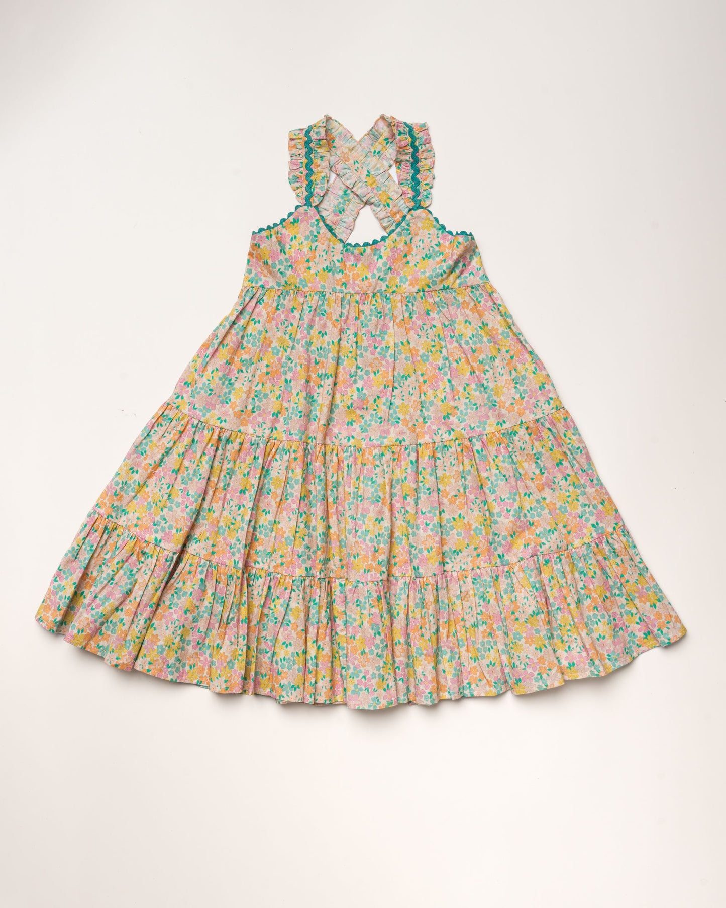 Early Sunday, Laura Dress in Emma Floral Mint color, made from printed 60s cotton cambric fabric, featuring Crisscross ruffle straps with delicate trim accents and a softly gathered tiered skirt, shown in a front flat-lay view